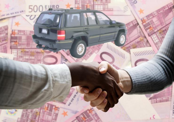 mani che si stringono e auto