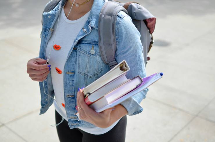 ragazza con zaino e libri