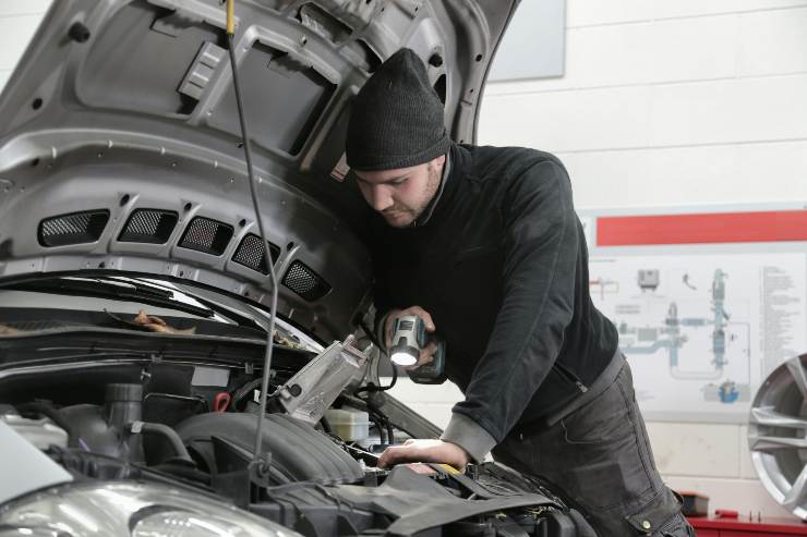 meccanico che controlla motore auto