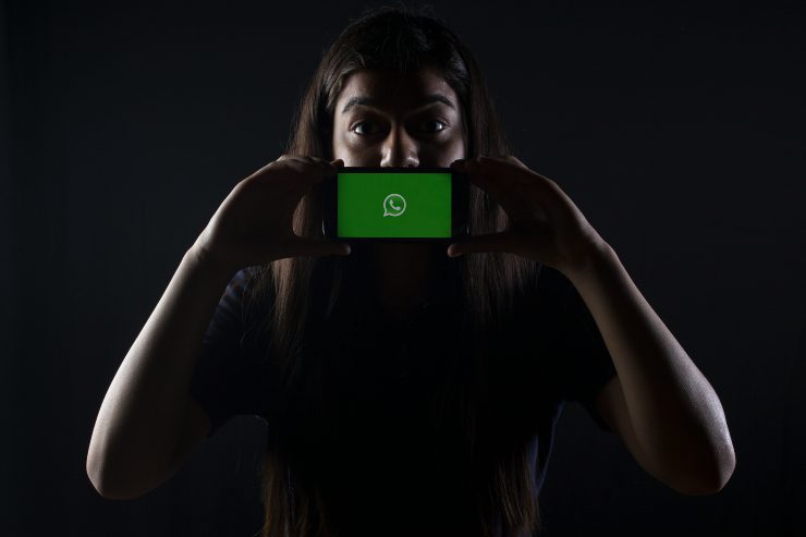 donna che si copre il volto con telefono
