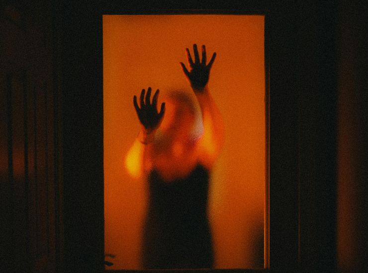 donna dietro a una porta con vetro chiusa