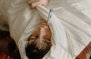 uomo malato con termometro in bocca